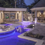 Outdoor living area with a pool and summer kitchen by Premier Magnolia Homes