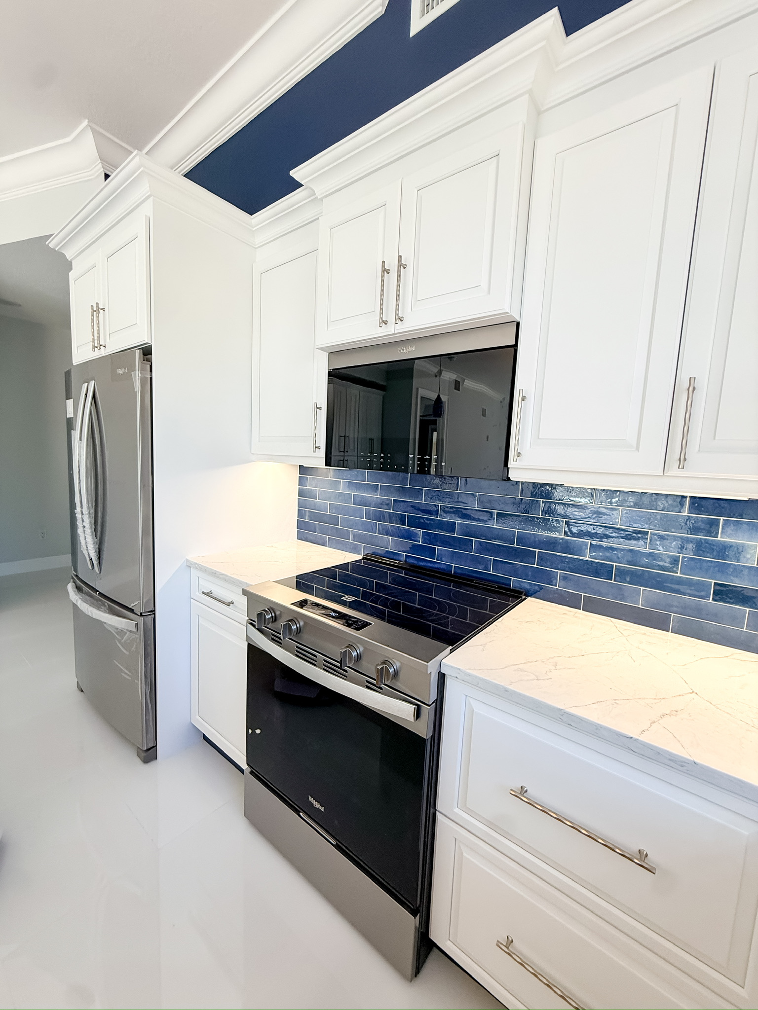 Renovated kitchen with white cabinetry, a large island and stainless appliances