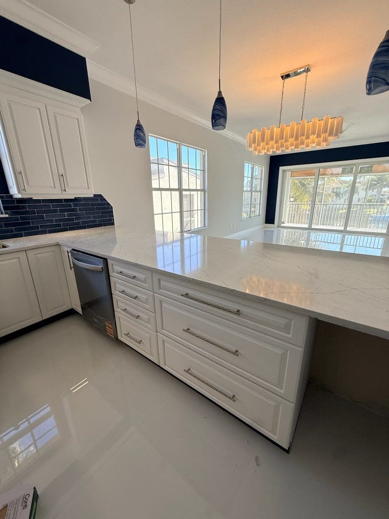 Remodeled kitchen with a navy island and white cabinetry