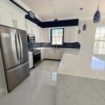 Navy blue island kitchen with white cabinetry by Premier Magnolia Homes