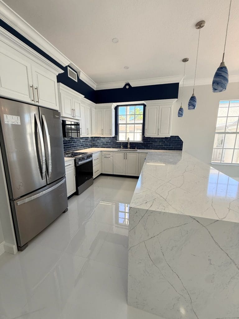 Navy blue island kitchen with white cabinetry by Premier Magnolia Homes