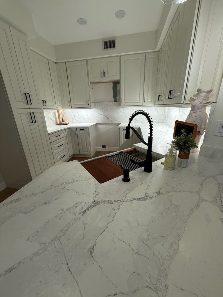 Marble waterfall countertop with a black faucet