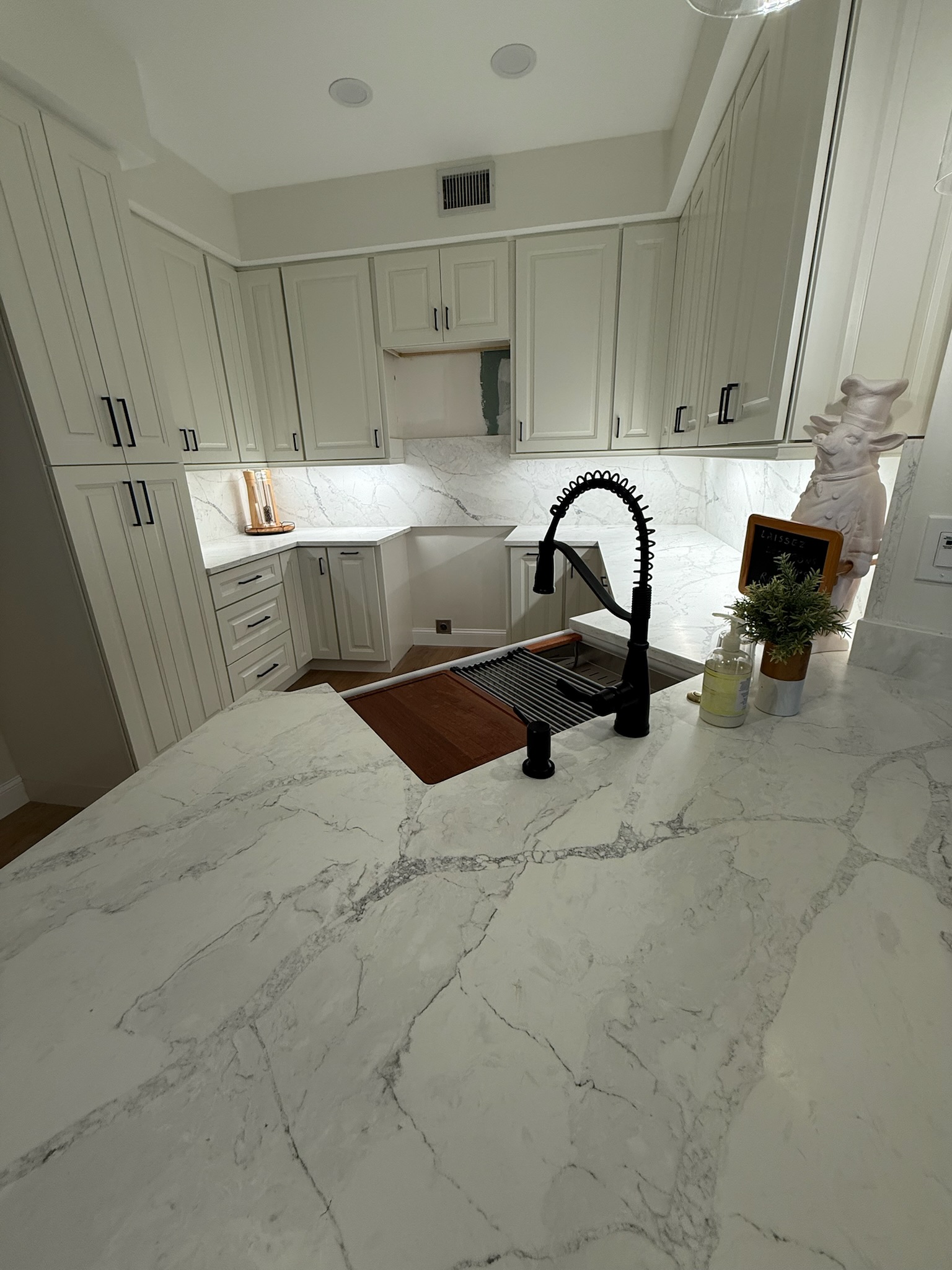 White custom kitchen with a quartz island by Premier Magnolia Homes