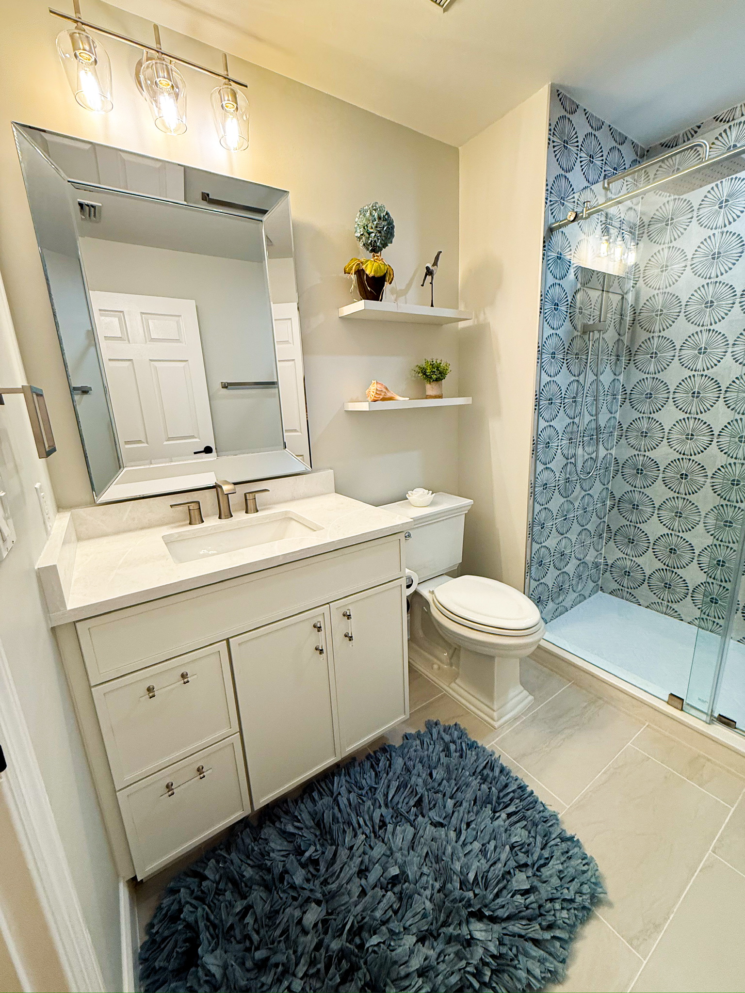 Primary bathroom vanity with a glass-enclosed walk-in shower