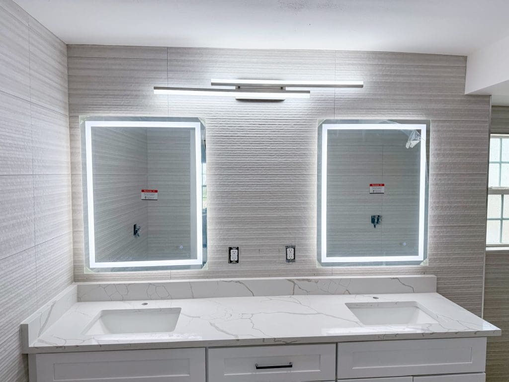Spacious primary bathroom with a long double vanity by Premier Magnolia Homes
