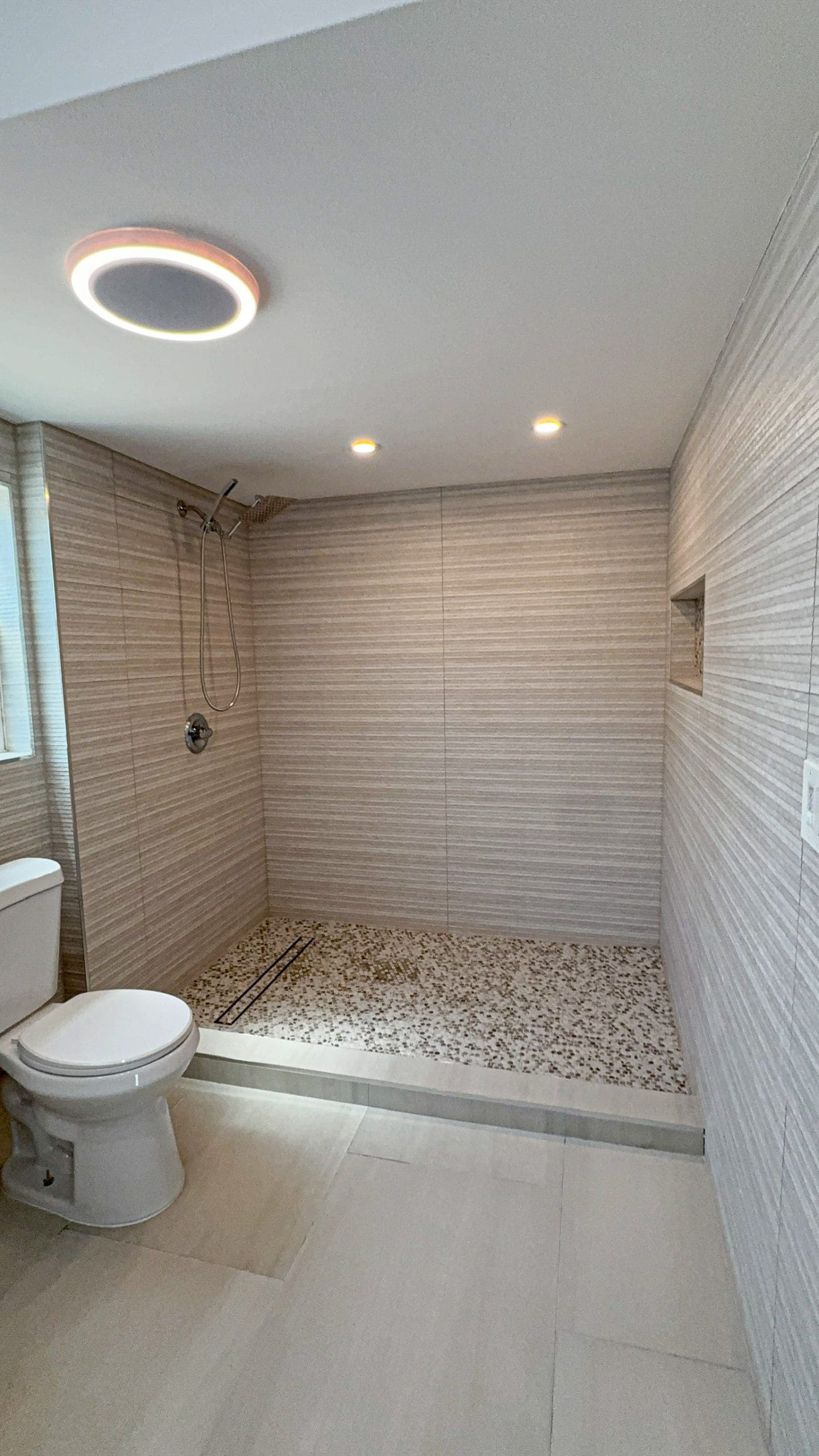 Walk-in shower with tile carried to the ceiling and a bench