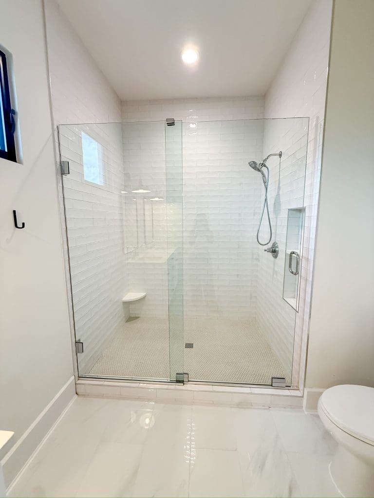 Walk-in shower with frameless glass, tiled floor to ceiling