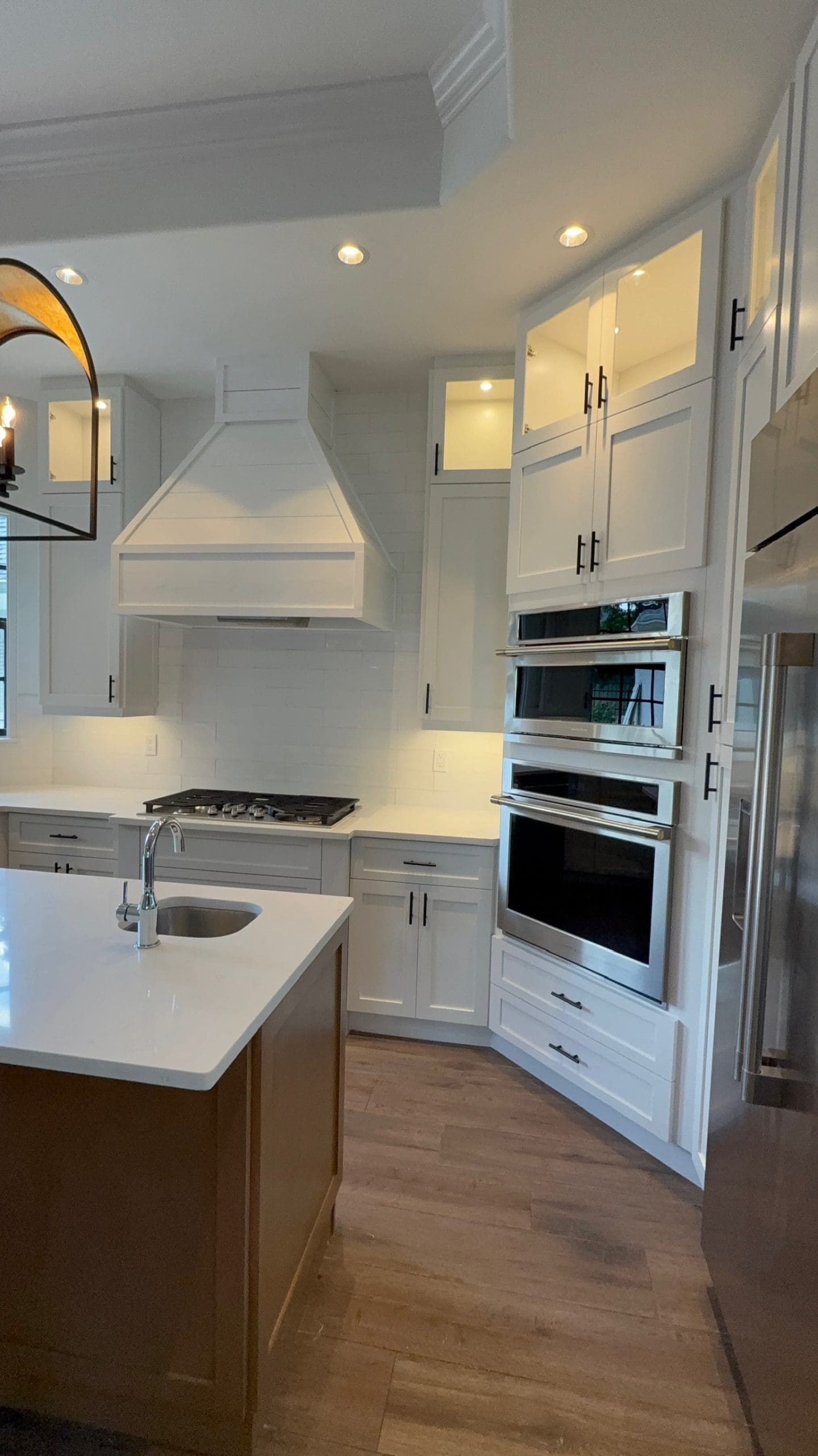 Remodeled estate kitchen with custom hood and wall ovens in a North Naples golf community home