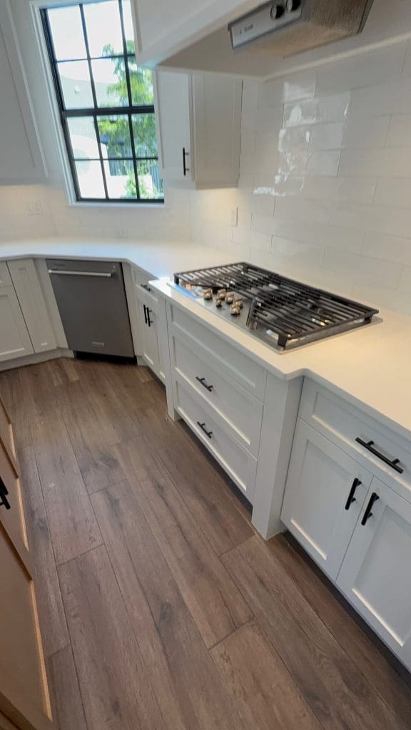 Custom kitchen with marble countertops and a gas cooktop by Premier Magnolia Homes