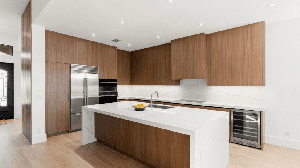 Custom walnut kitchen with a white quartz waterfall island in a Southwest Florida home